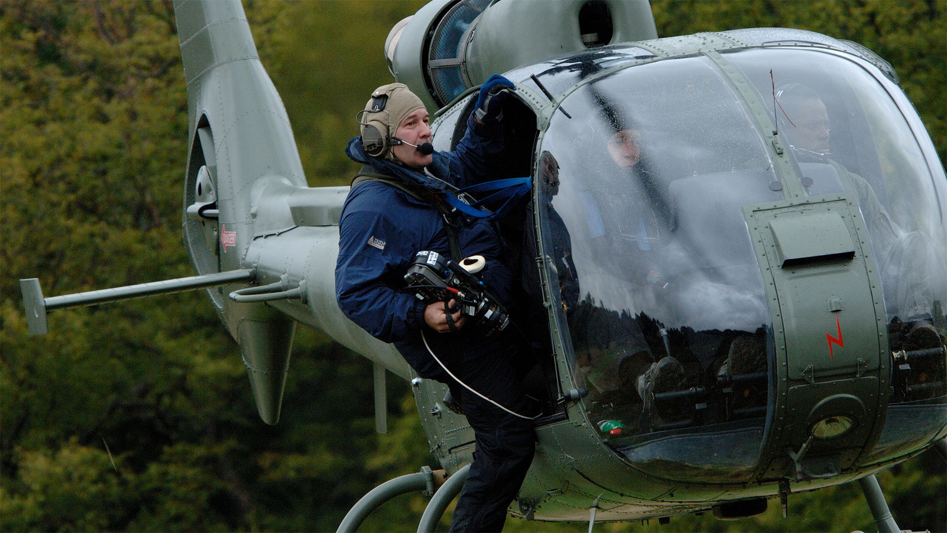 camera man hanging out a military helicopter